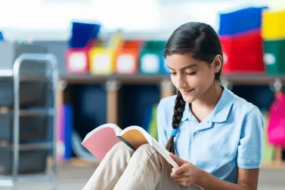 Image of a student reading a book outside