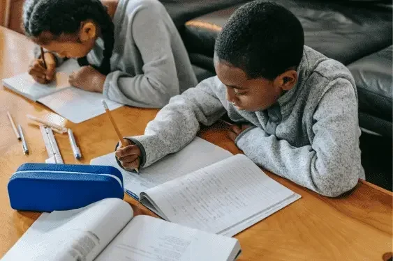 Image representing teenagers working on notepags on a table